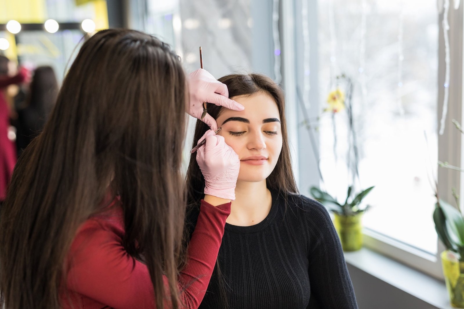 master doing make-up with wide eyebrow lines